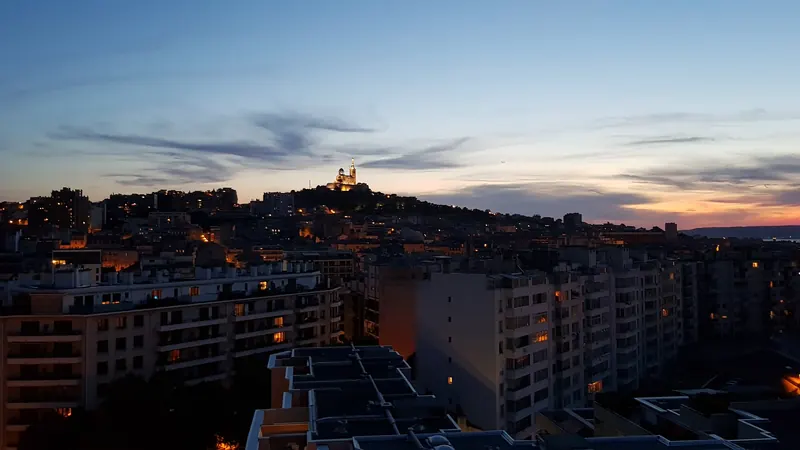 Silhouette de Notre-Dame de la Garde, la Bonne Mère, sur sa colline au crépuscule au-dessus des toits de Marseille