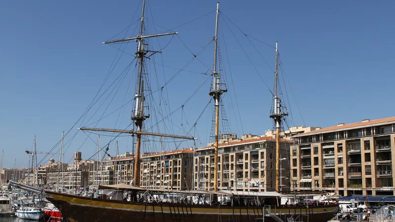 Un voilier trois-mâts amarré dans le Vieux-Port de Marseille devant les immeubles du quai