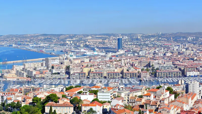 Panorama de Marseille vu depuis Notre-Dame de la Garde : toits de tuiles, Vieux-Port et port de commerce jusqu'à la mer