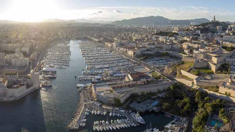 Vue aérienne du Vieux-Port de Marseille au coucher du soleil, entre le fort Saint-Nicolas et le fort Saint-Jean
