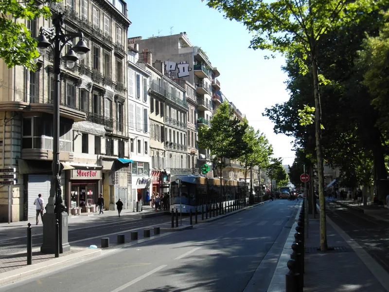La Canebière, grande avenue bordée d'arbres et d'immeubles haussmanniens dans le 1er arrondissement de Marseille