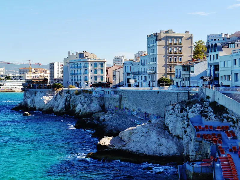 Rochers et eau bleue au pied des immeubles de la corniche vers Malmousque, dans le 7e arrondissement de Marseille