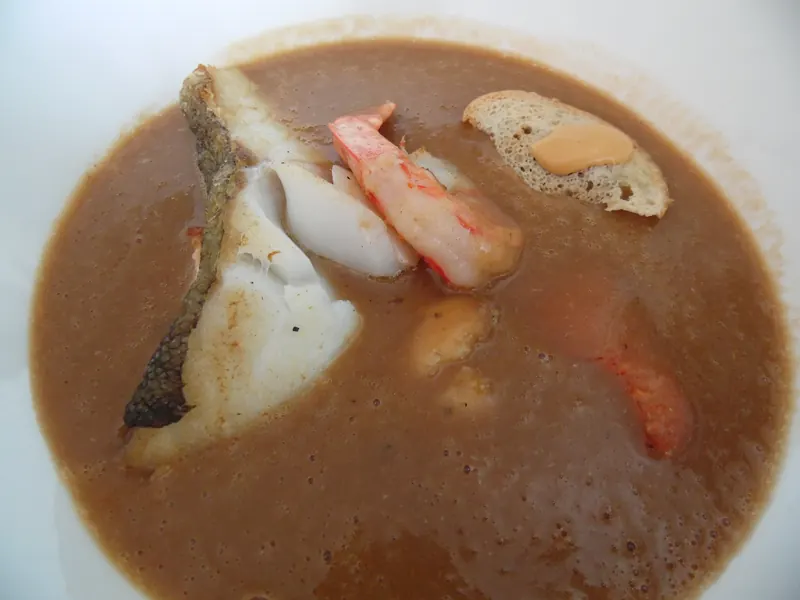 Assiette de bouillabaisse avec poisson, langoustine et croûton tartiné de rouille