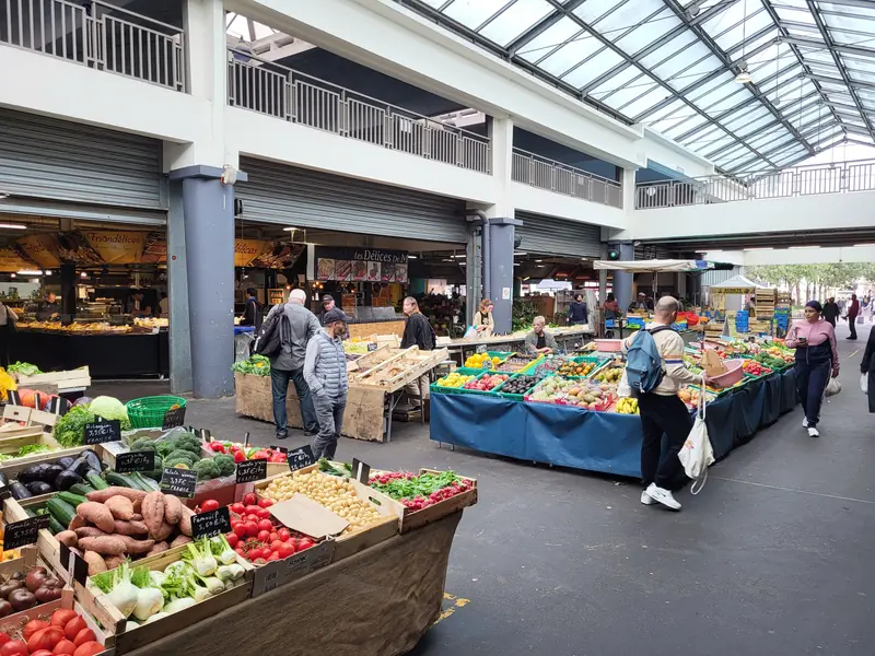 Étals de fruits et légumes frais sous la halle du marché des Capucins à Noailles, Marseille